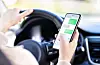 Driving car and using phone. Distracted driver texting with mobi