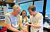 Martin Lidal (til høgre) viser Leif Gunnar Mo korleis apparatet fungerer. I midten Emilie Blokhus.